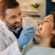 dentist checking for vitamin b12 deficiency symptoms in mouth Caption: Regular dental check-ups can help catch early oral signs of vitamin B12 deficiency.
